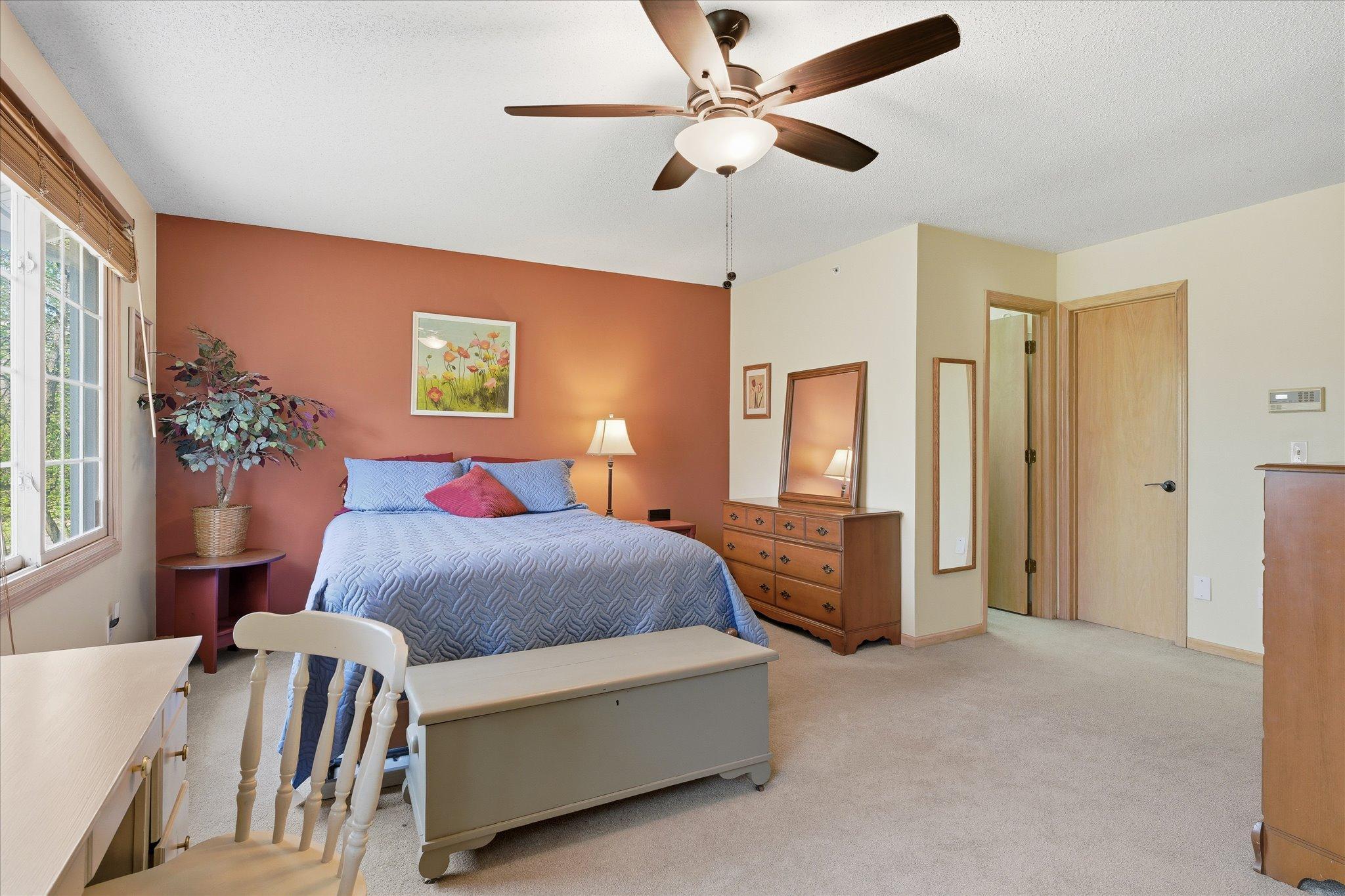 Bright and comfortable primary suite featuring multiple windows for natural light and a functional layout.