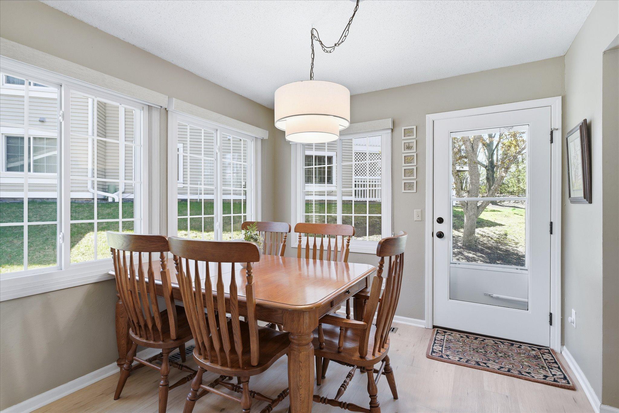 Sunny dining space with wall of windows and access to outdoor patio, perfect for everyday meals or entertaining.