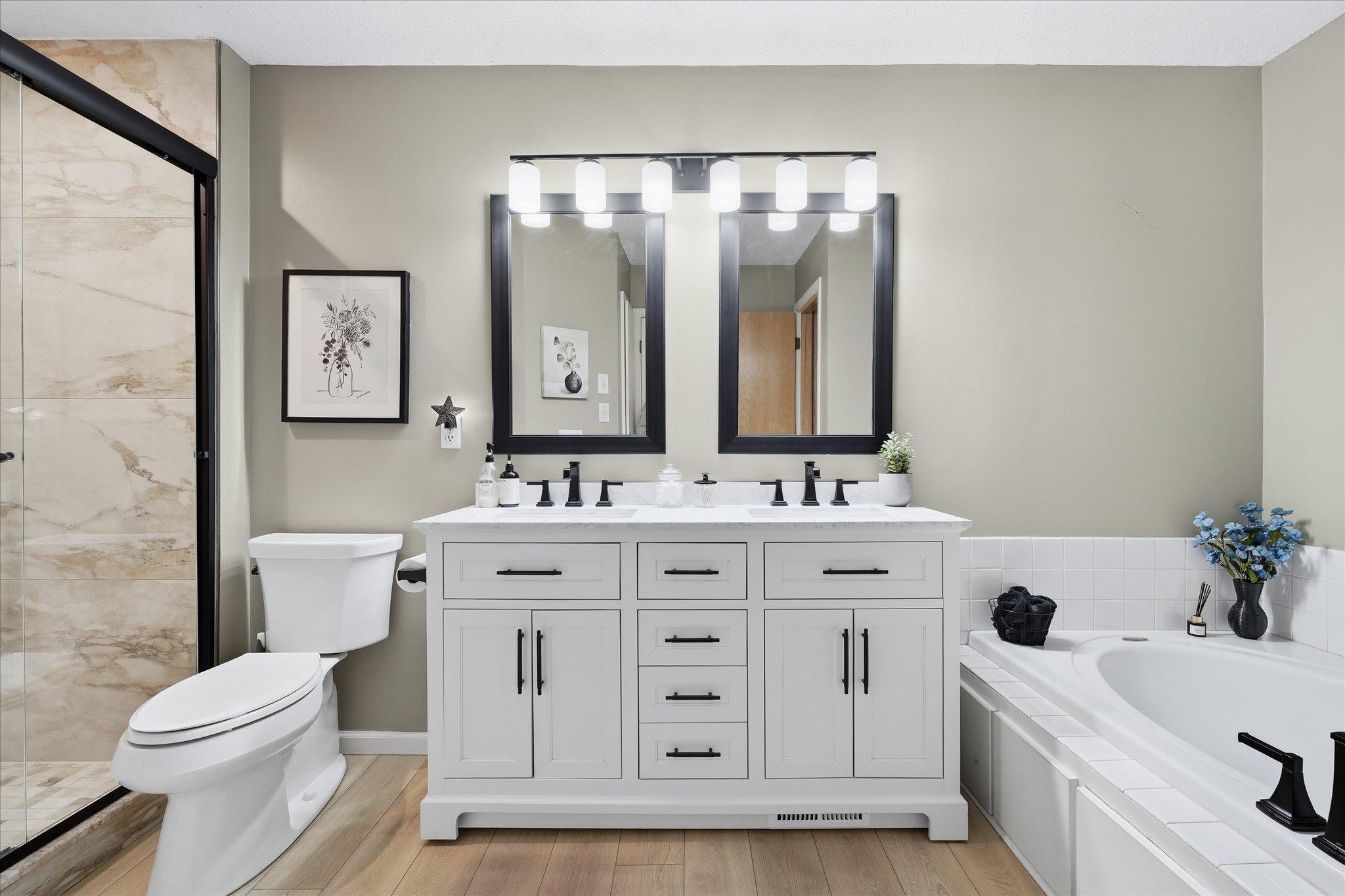 Beautifully updated bathroom featuring dual sinks, walk-in shower, and separate soaking tub.