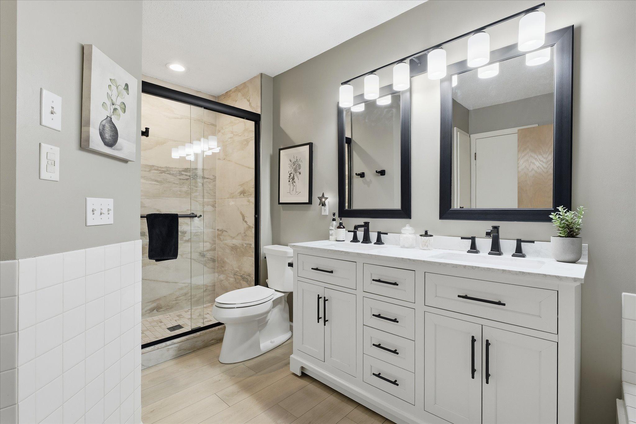 Stylish walk-in shower with tile surround, glass door, and modern finishes.