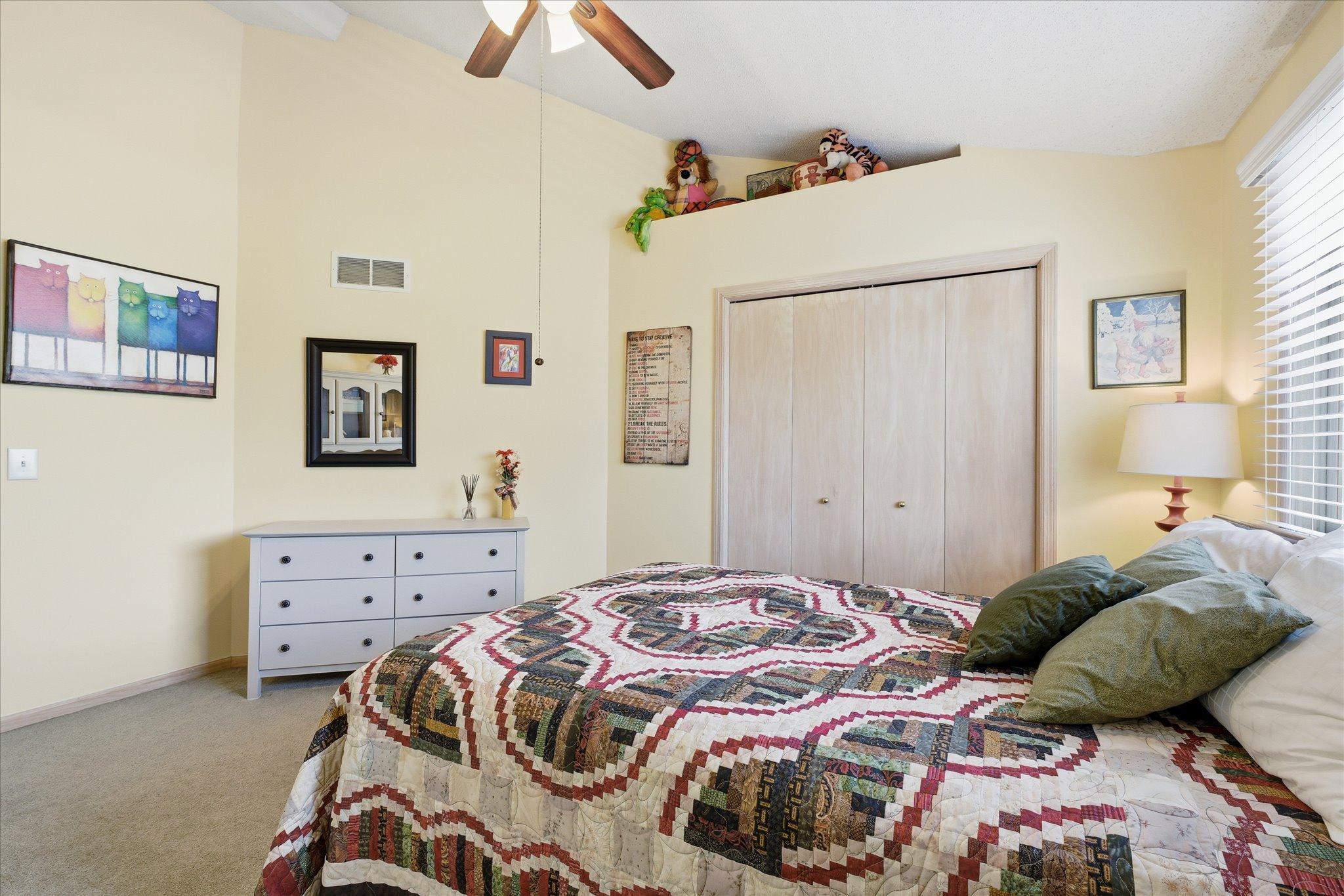 Spacious bedroom #3 with vaulted ceiling, neutral tones, and ample closet space.