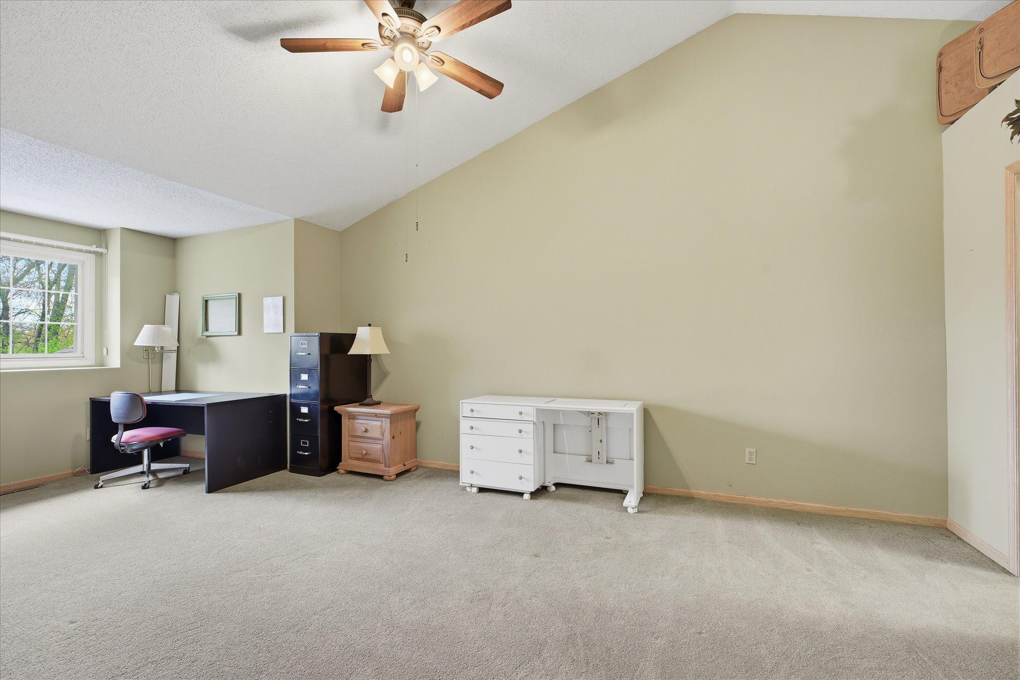 Spacious primary bedroom #2 with walk through bath on the upper level with vaulted ceiling, neutral tones, and ample closet space.