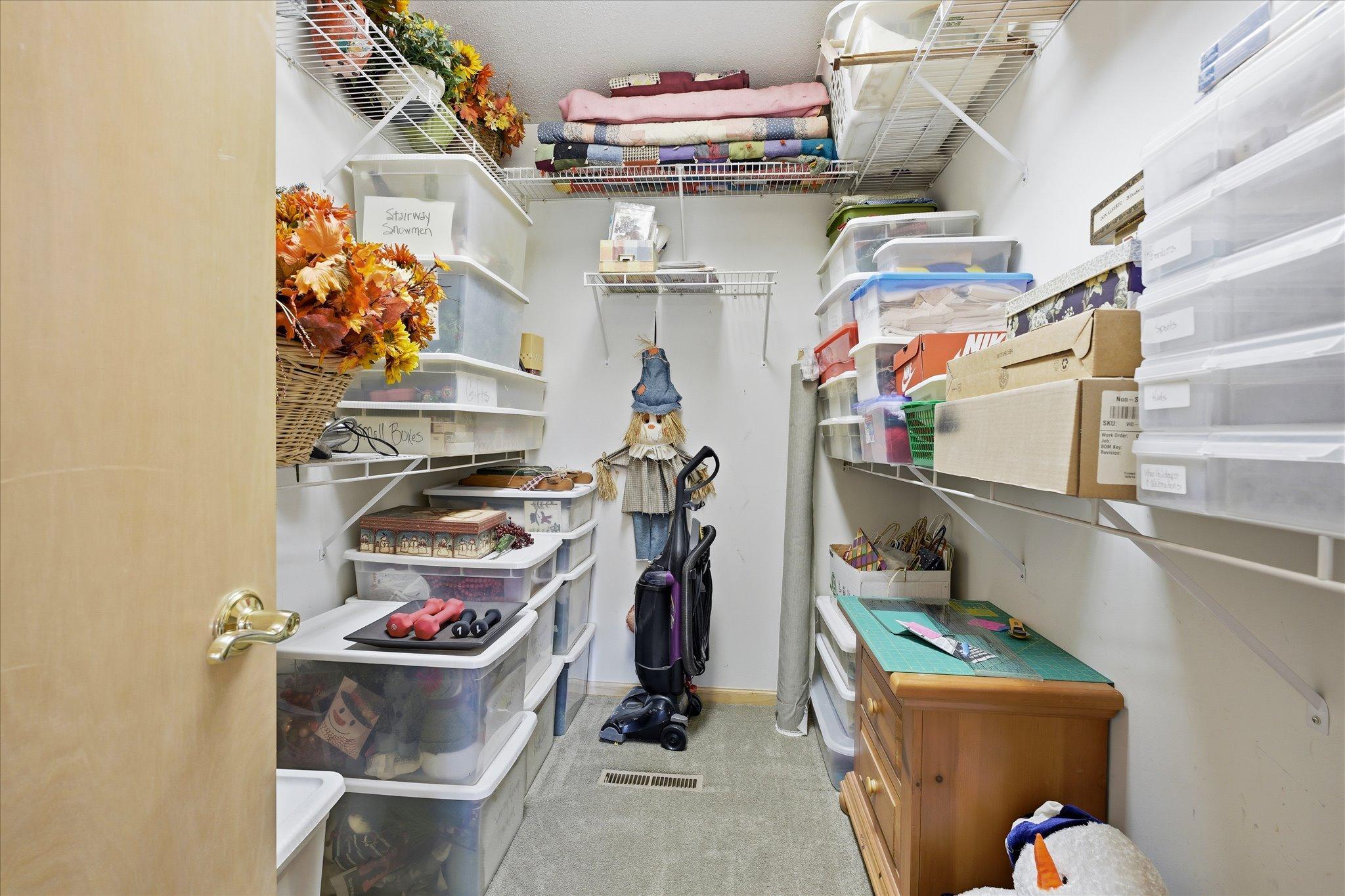 Generous walk-in storage room with built-in shelving for organized storage.