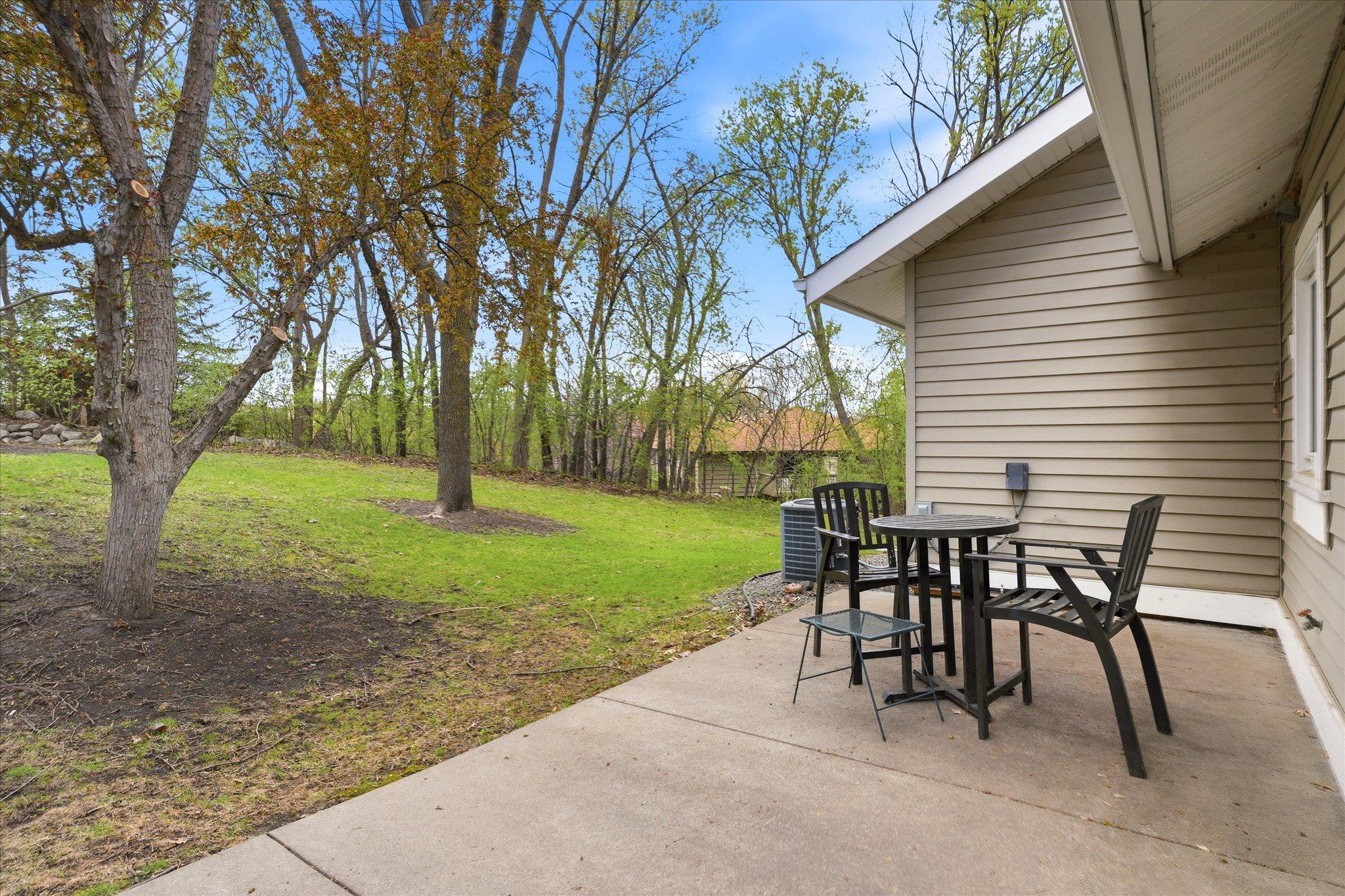 Quiet backyard setting with mature trees providing privacy and a peaceful backdrop.