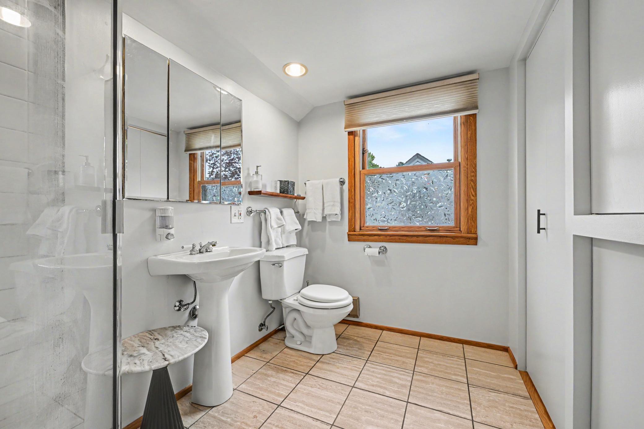 Bathroom - upper level with shower in foreground and nice natural stone/marble squares.
