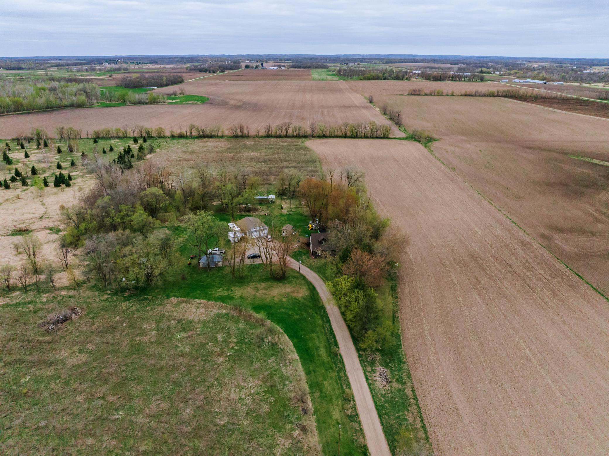 House and outbuildings surrounded by trees