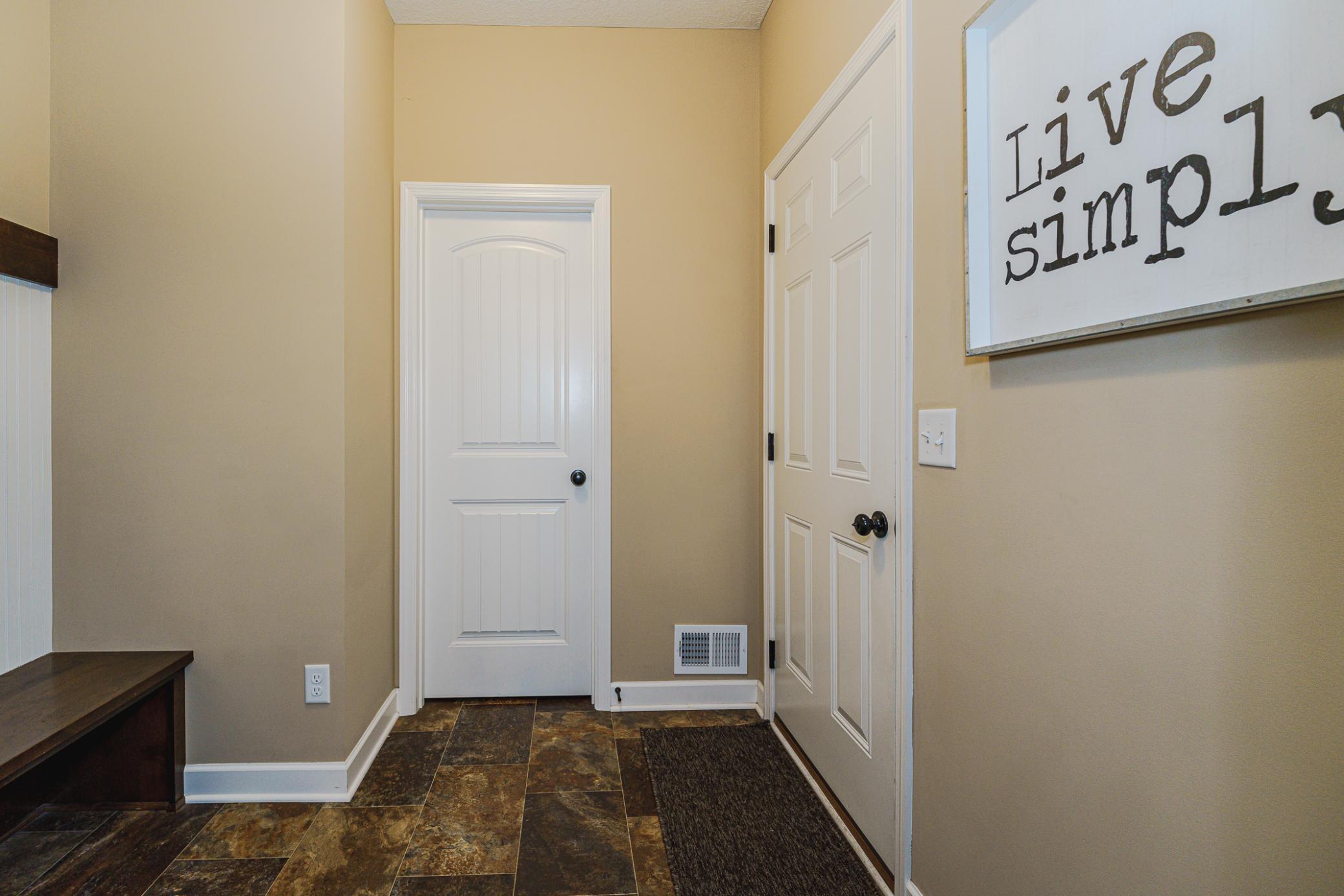 The mud room is practical, with a HUGE walk-in closet and a boot bench.
