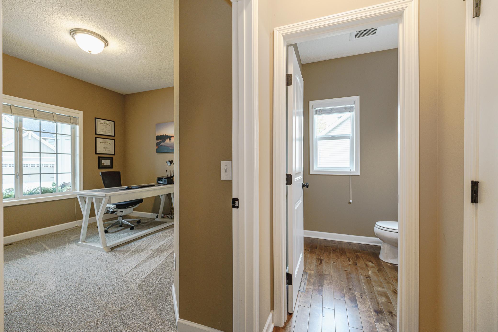 The main floor includes an additional bedroom with NEW CARPET as of April 2026. This bedroom makes a great office as well, and has a single glass entry door, a closet, and bright windows overlooking the porch.