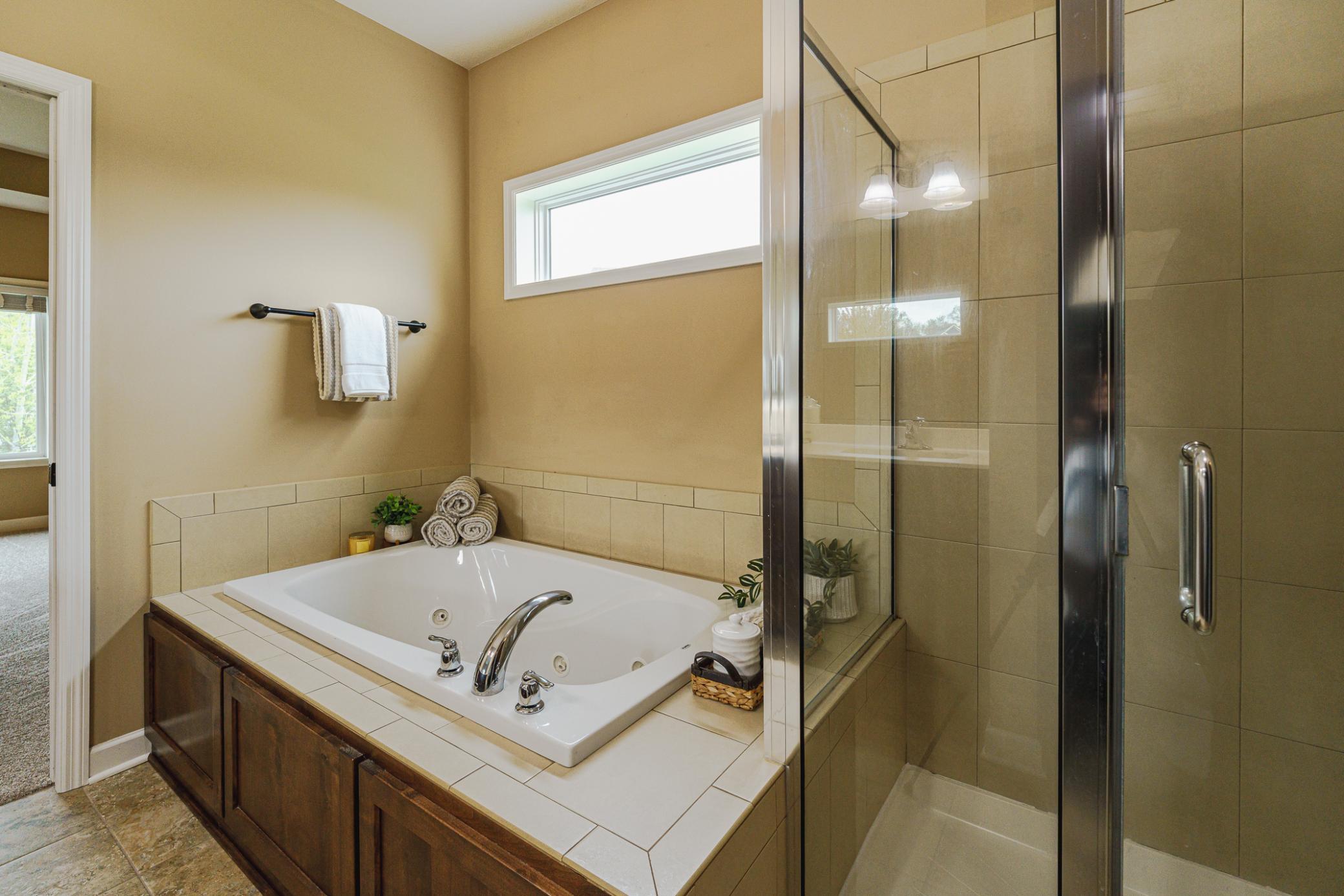 The tub is jetted, and a transom window in the bathroom lets in natural light. The tile shower also receives this nice light.
