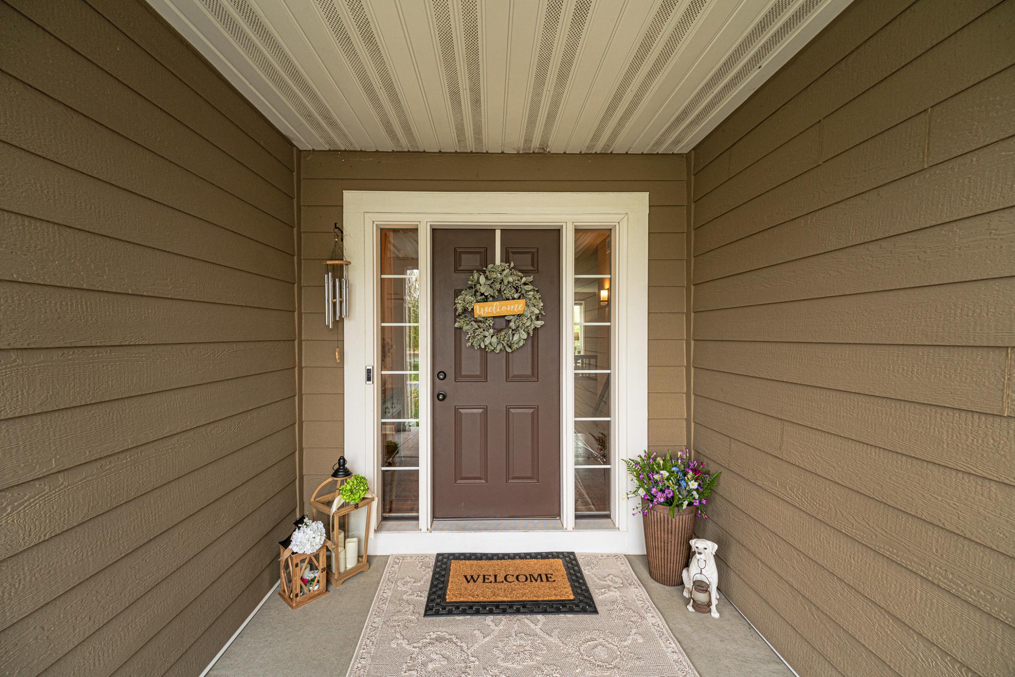 The covered front entrance features symmetrical full-view sidelight windows and space for your welcoming decor.
