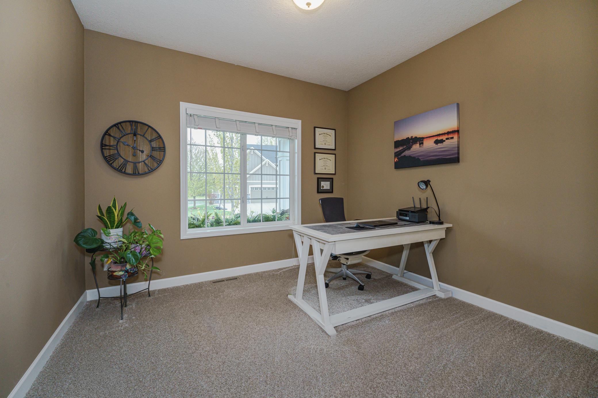The main floor includes an additional bedroom with NEW CARPET as of April 2026. This bedroom makes a great office as well, with a closet, and bright windows overlooking the porch.