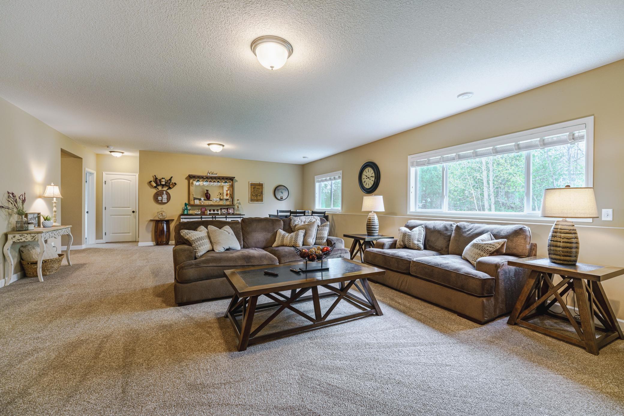 The living space has white trim and is illuminated by recessed lighting and abundant windows.