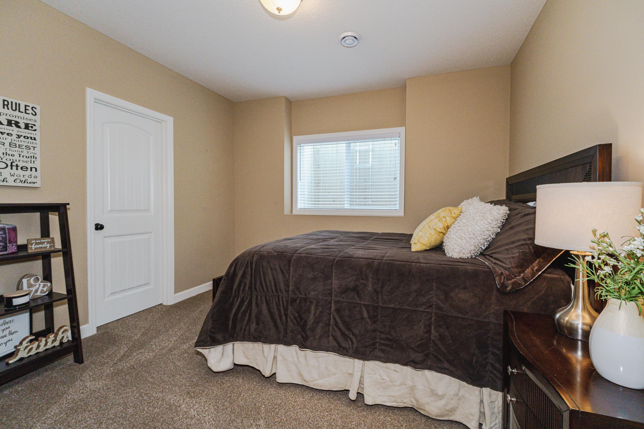 The lower level bedrooms are generous in size and have a large windows and white trim. Both rooms have walk-in closets. This room has an egress window.