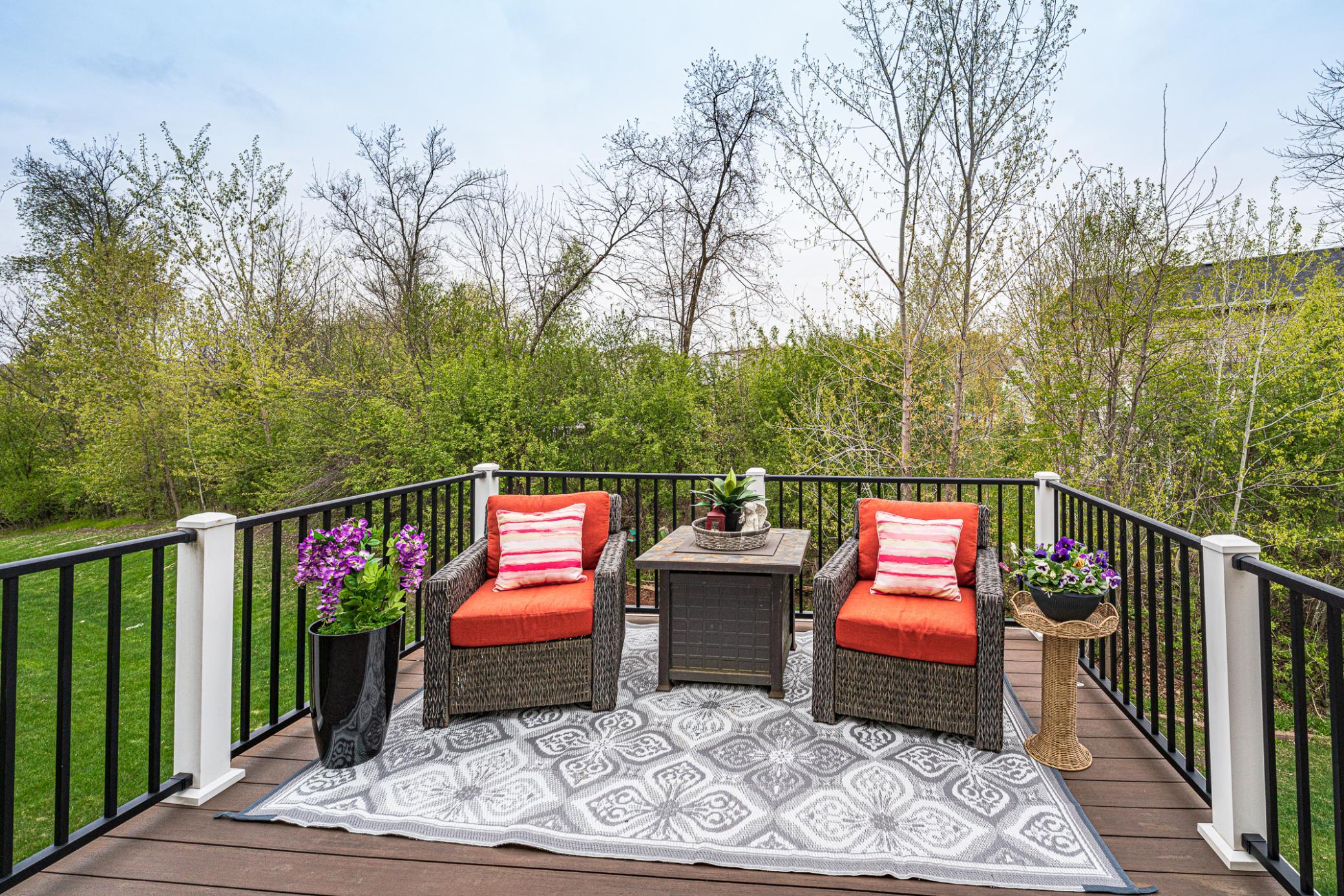 The composite deck backs to a row of green trees and is a relaxing area, conveniently located off the kitchen.
