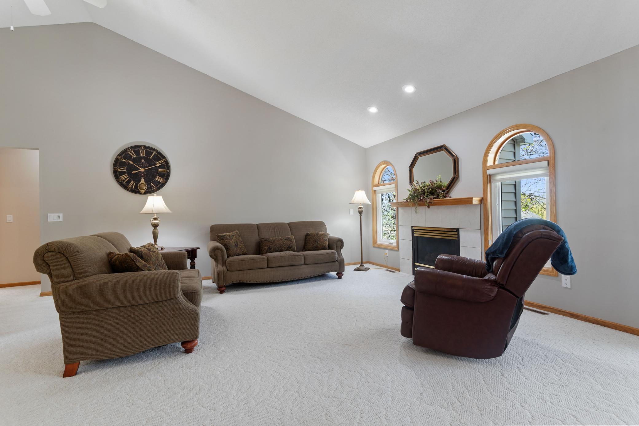 Main level Living room is warmed by a gas fireplace with lighting above. Windows on each side, plus 1/2 round transoms offer additional daylight.