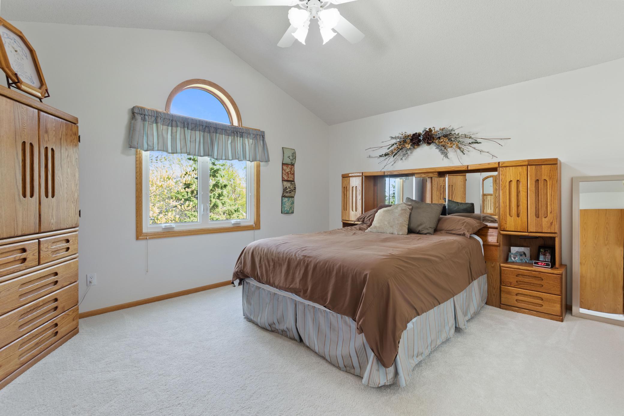 Well sized owners suite with vaulted ceiling, ceiling fan, plus 1/2 round transom above window