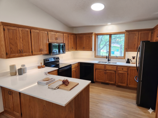 Main level: kitchen with new black stainless appliances, quartz counters, and lvp flooring (virtually staged)