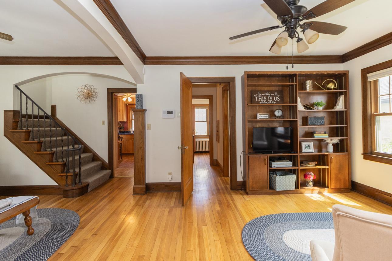 Exquisite character fills the main level with hardwood floors, detailed ceiling molding, built-in shelving, and an eye-catching staircase