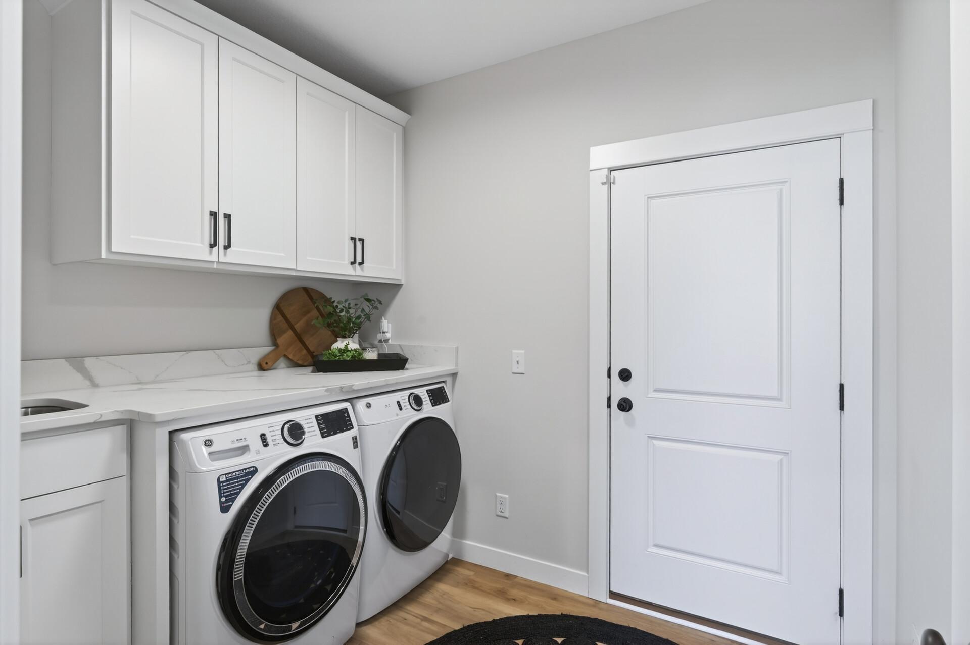 Convenience meets function with a well-designed laundry and mudroom just off the garage, complete with a sink and built-in bench, along with an additional built-in drop zone near the front entry