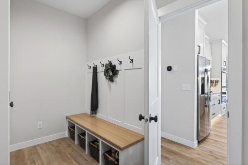 Convenience meets function with a well-designed laundry and mudroom just off the garage, complete with a sink and built-in bench, along with an additional built-in drop zone near the front entry