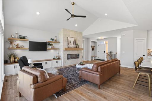 Stunning living room with an electric fireplace and tiled surround, flanked by custom built-in cabinetry