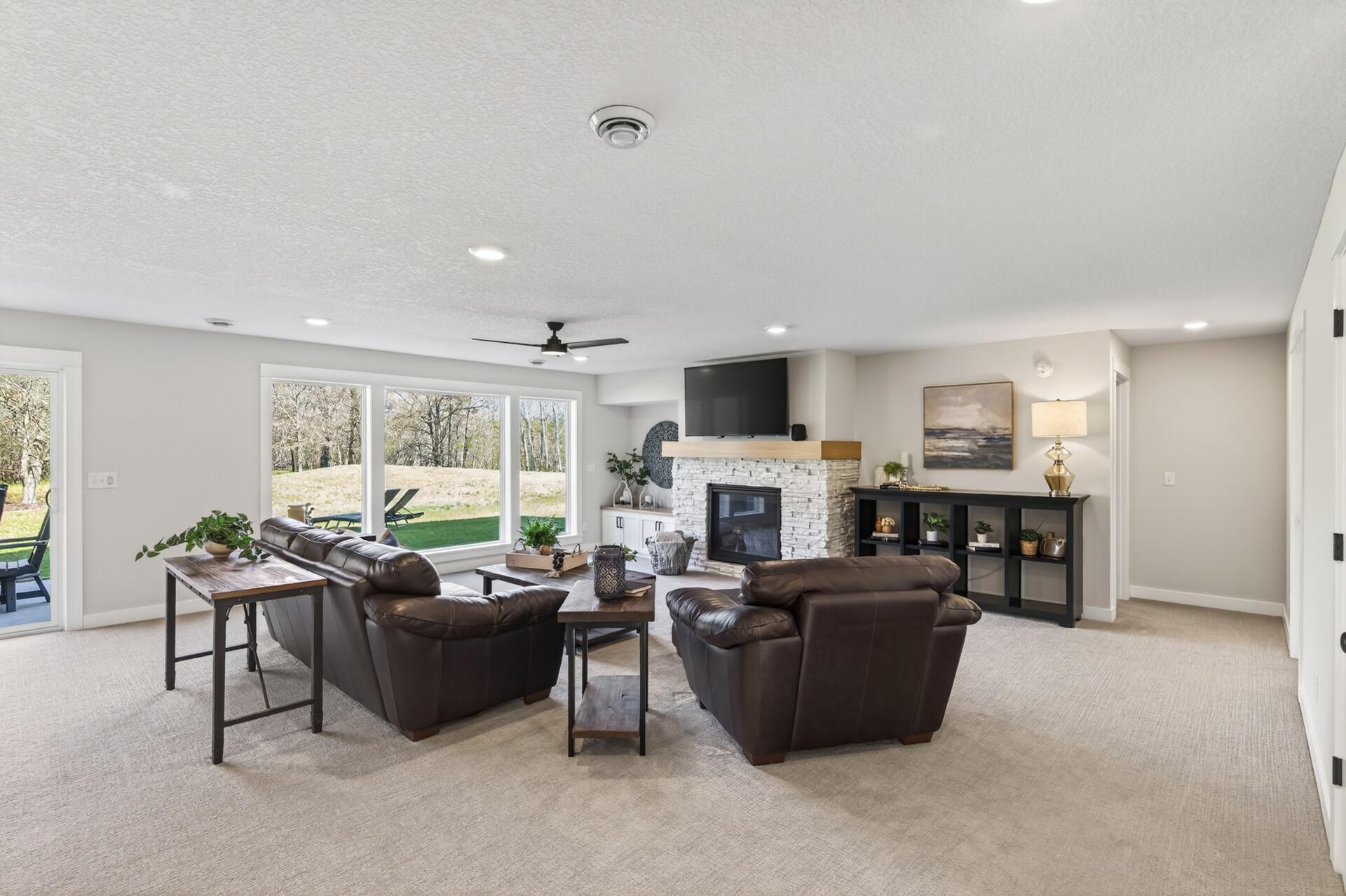 The finished walkout lower level expands the living space with a large family room, wet bar, and a second gas fireplace with brick surround, built-ins, and a white oak mantle, creating a warm and inviting atmosphere.