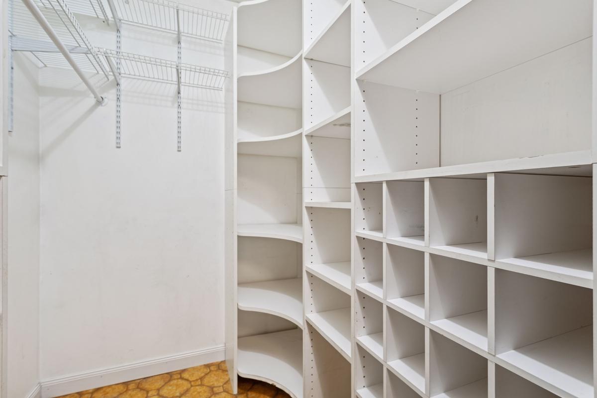 Spacious front-entry foyer featuring a versatile walk-in pantry/closet with built-in cubbies designed for organized storage of shoes, clothing, and everyday essentials. Keeping everything neatly arranged and easily accessible right as you enter.