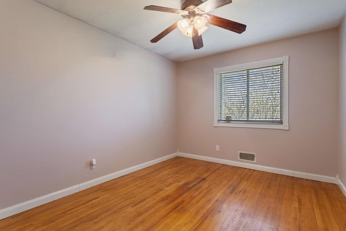 Two bedrooms up, two down. Filled with natural light, this front facing bedrooms features classic hardwood floors, a ceiling fan for year-round comfort, and a nicely sized closet.
