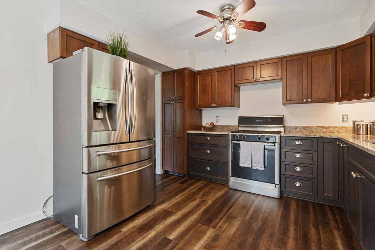 Stylish, updated kitchen featuring, plank flooring, and stainless steel appliances. The convenient pantry with pull-out drawers provides extra storage.