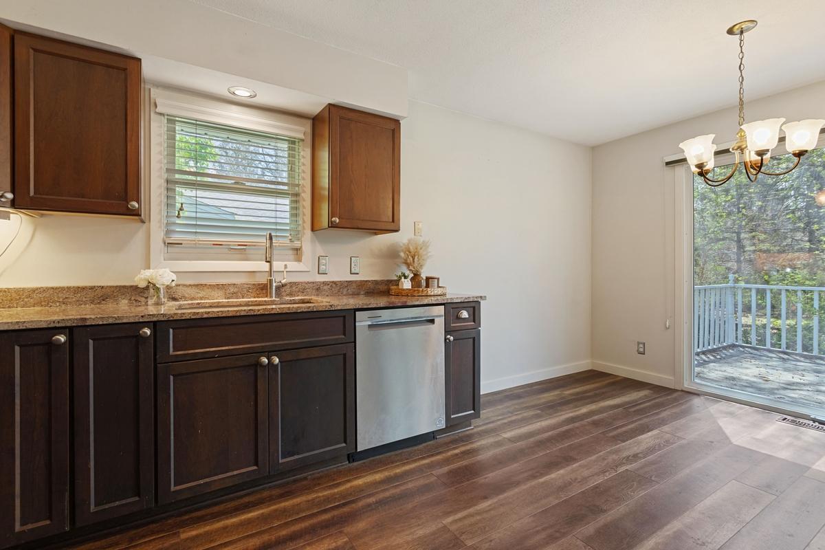 Warm and inviting kitchen with plank flooring and an open flow into the informal dining area-perfect for everyday meals & casual gatherings. The sliding door offers easy access to the deck with included natural gas grill, connected to a gas line.