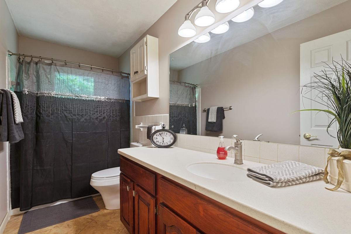 The full bathroom has a spacious vanity with hard surface countertop and tiled backsplash. The bathroom has a ceramic tiled half-wall for added definition & function. The tub with fully tiled surround, offers a clean, modern, and easy-to-maintain.