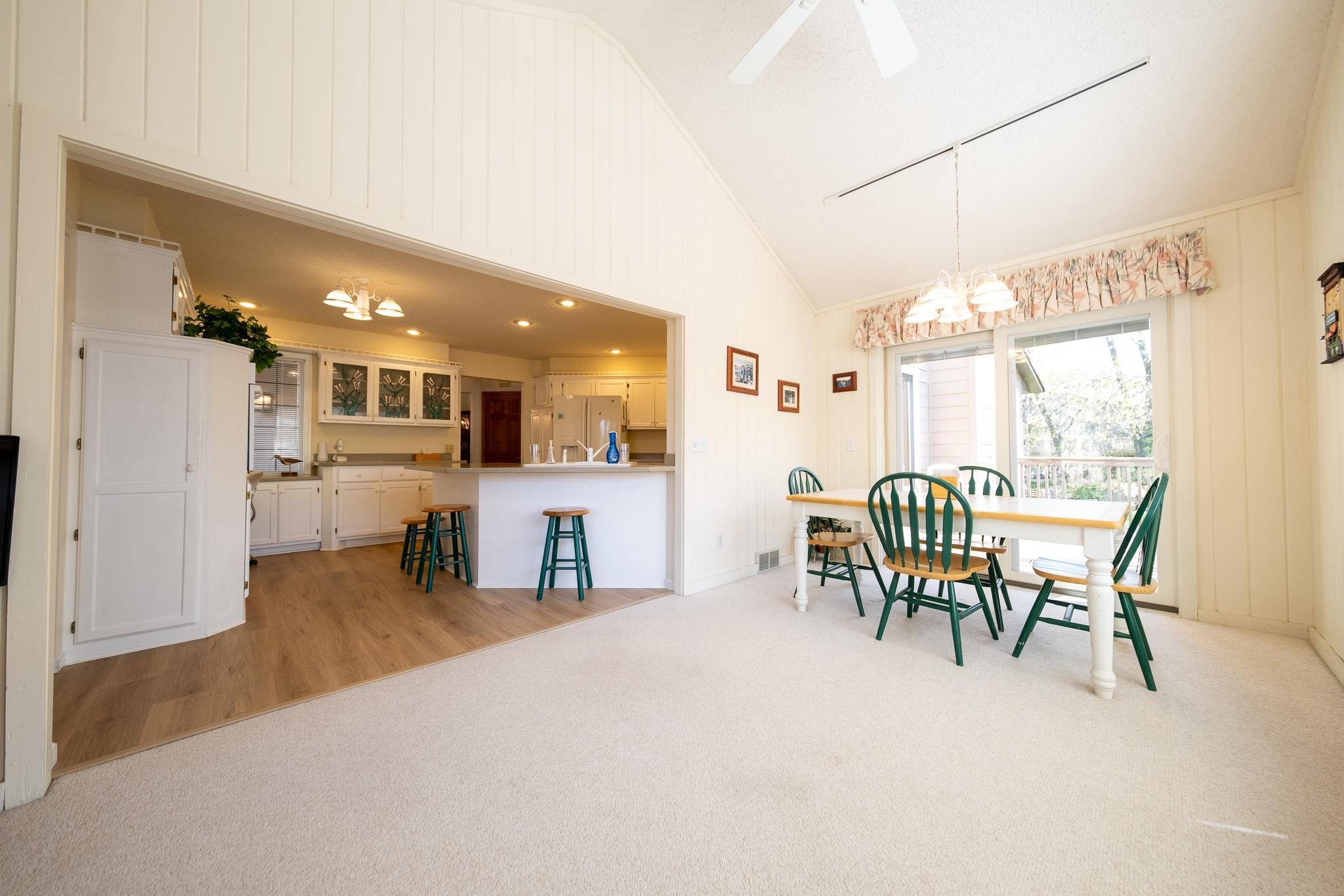 View of the kitchen and casual dining room (with patio doors that lead to a side deck too!