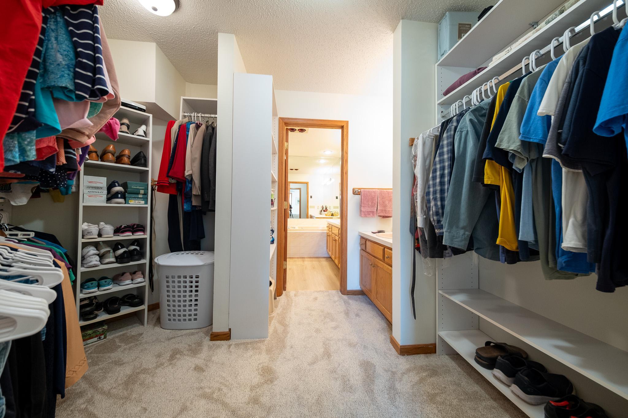 Large walk-in closet with shelving and racks on both sides