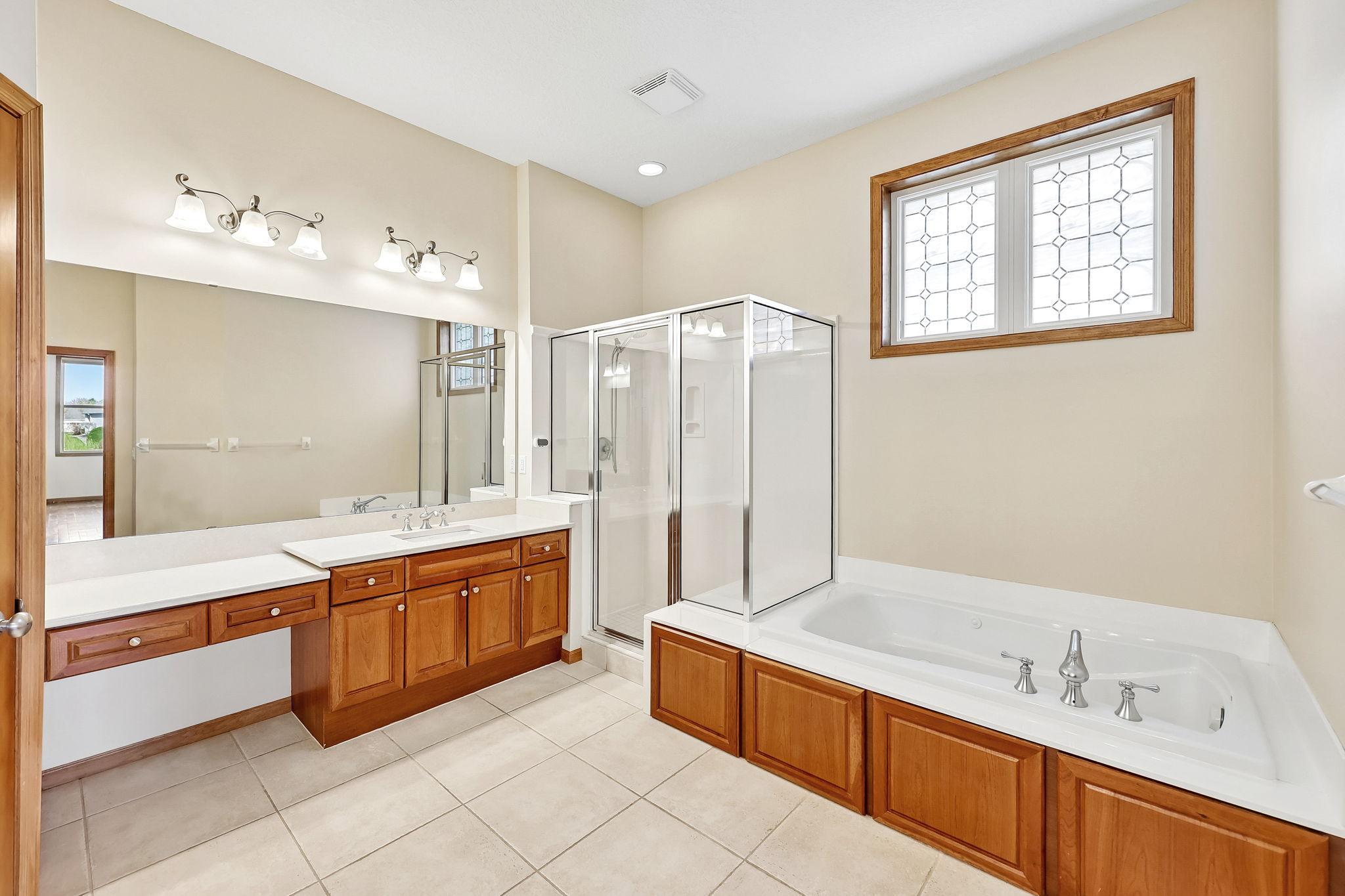 Primary bath with separate tub and shower, vanity, and double sinks