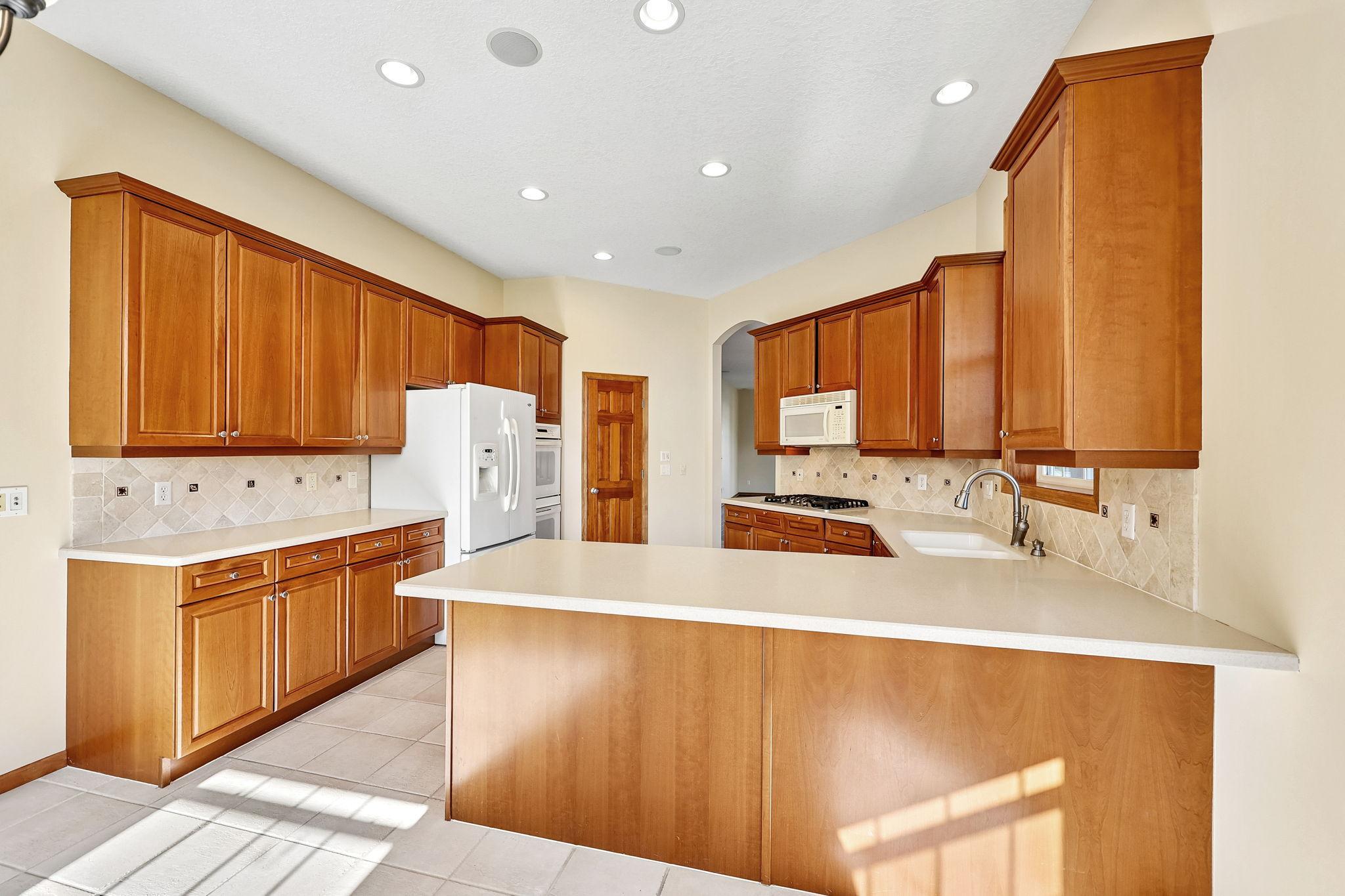 Kitchen is bright, with window overlooking the yard