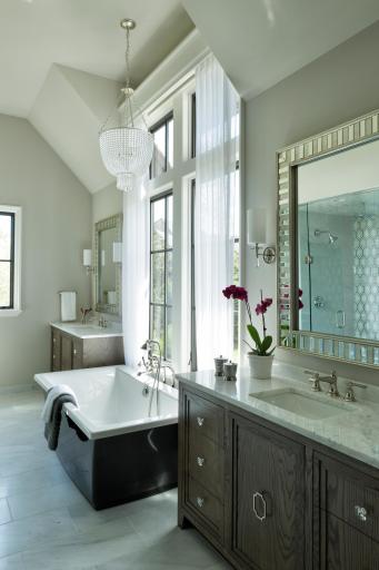 Heated floors, a stand-alone soaking tub, power shades, and marble tile