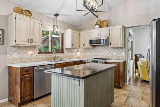 Kitchen with tile floors, backsplash, stainless steel appliances.