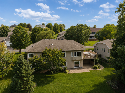 Walkout backyard setting with mature trees, outdoor living space, and lake views.