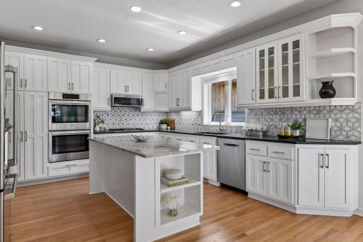 New updated kitchen with white enameled cabinetry, beautiful countertops, and stylish backsplash.