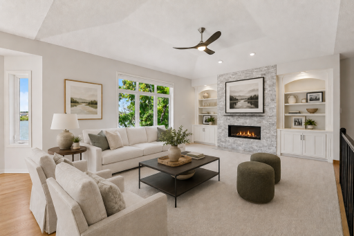 Freshly updated great room with built-ins, gas fireplace, and lake views. (Virtually staged.)