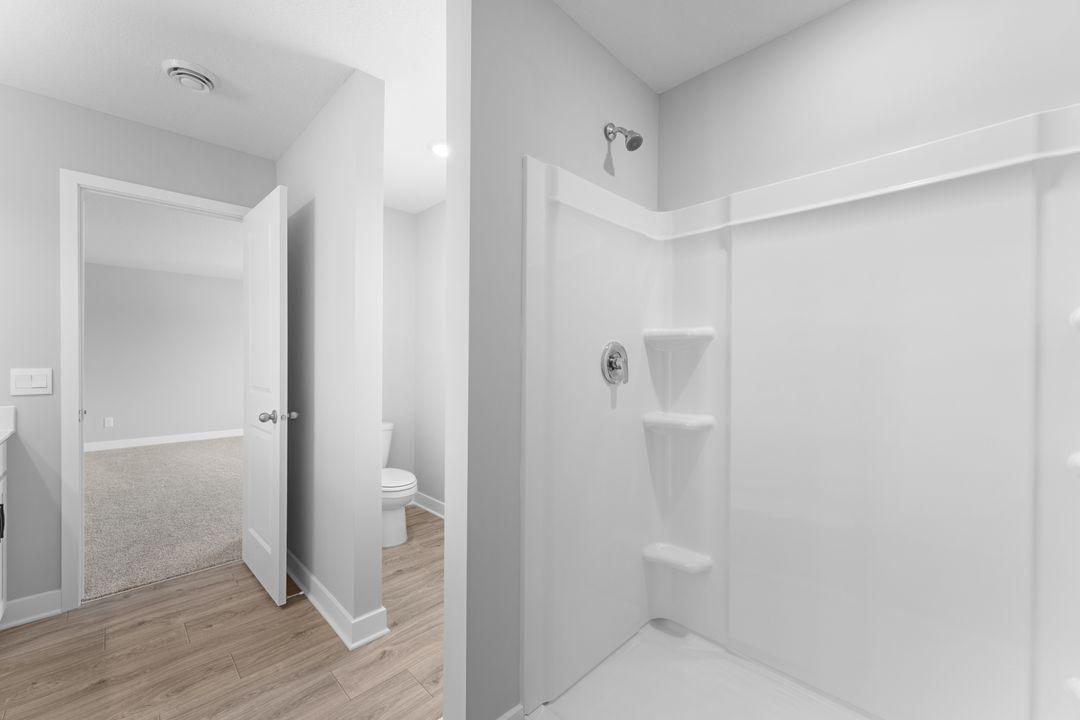 Private ensuite bathroom with walk-in shower stall and separate stool room off the primary bedroom. *Picture is of inventory home; actual finishes may vary.