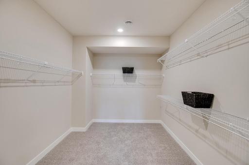 The primary suite's expansive walk in closet. Photo of model, colors and finished will vary.