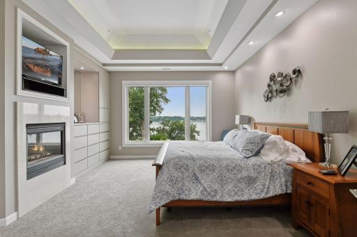 Main level primary suite features gas fireplace and beautiful views of the lake!