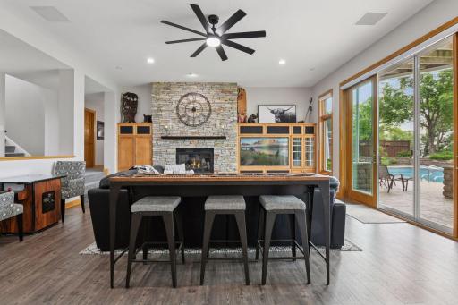 Large family room offering a gas fireplace with stone surround.