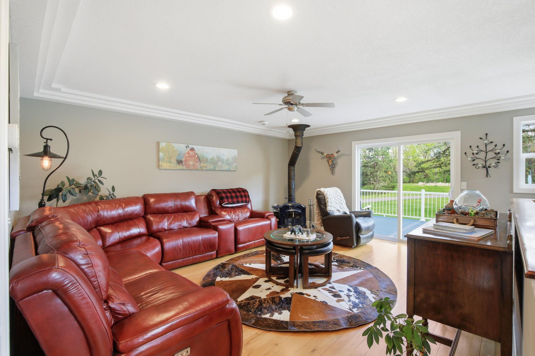 Comfortable Living Room with wood stove, great natural light, and access to the wraparound deck.