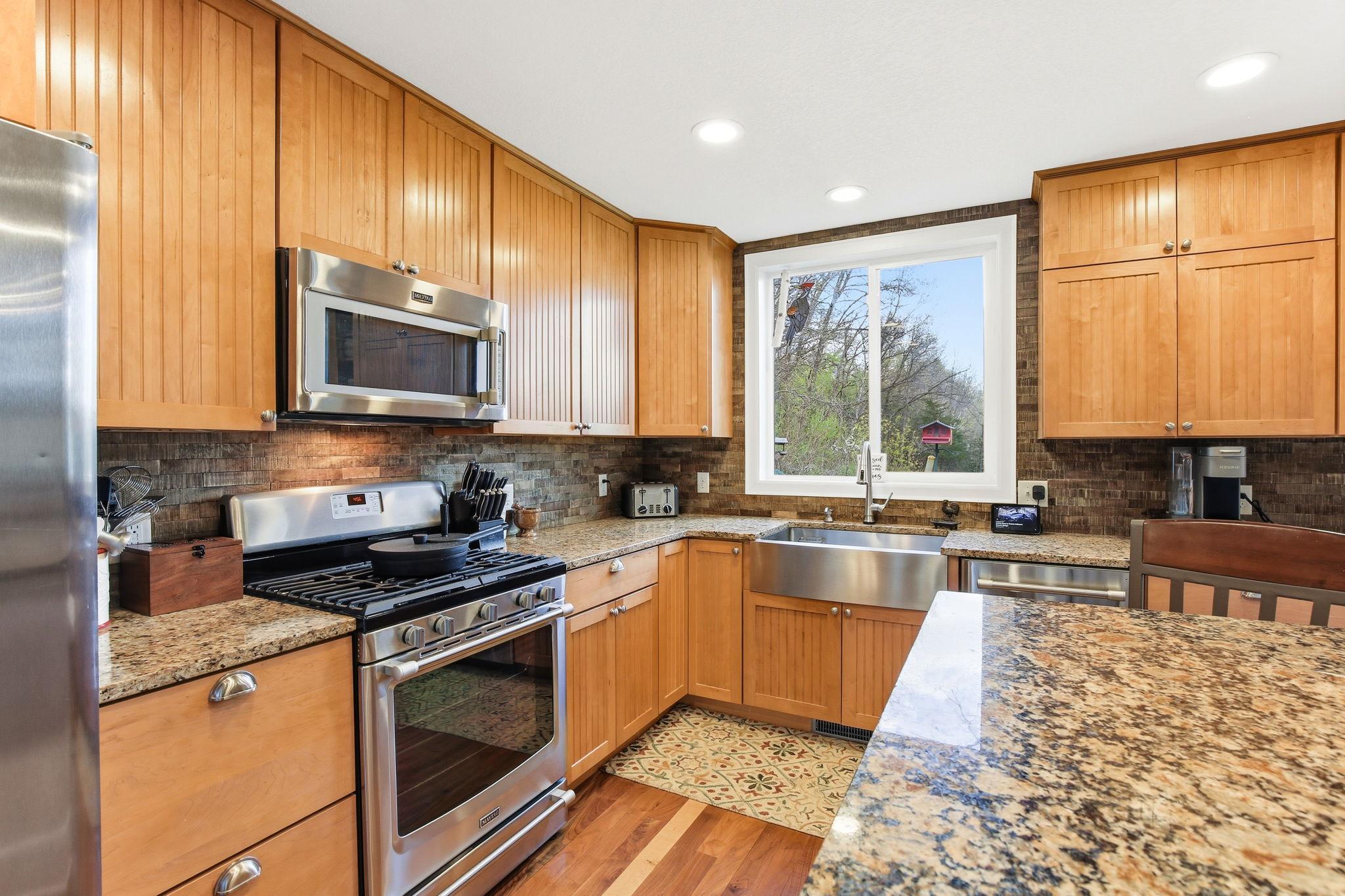Granite counters, gas stove, stainless appliances, and quality cabinetry complete the Kitchen.