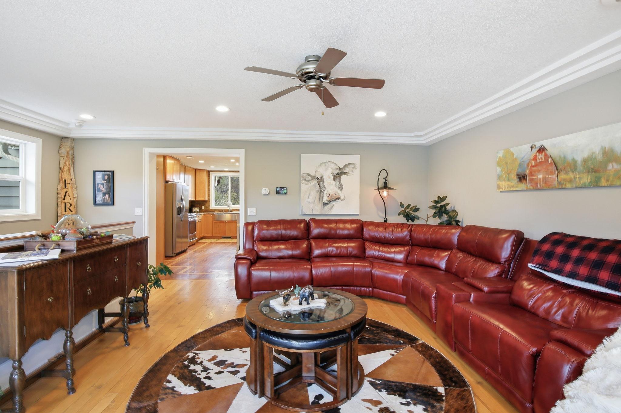 Spacious Living Room with custom trim, wood stove, and open flow to the Kitchen.