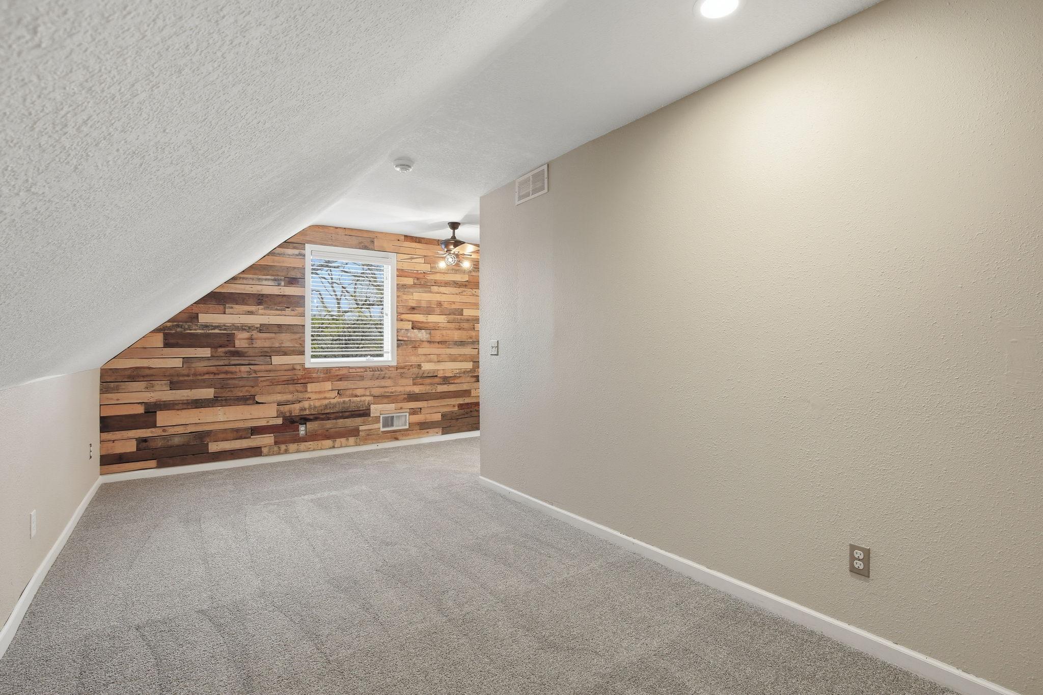 2nd bedroom features a wood accent wall.