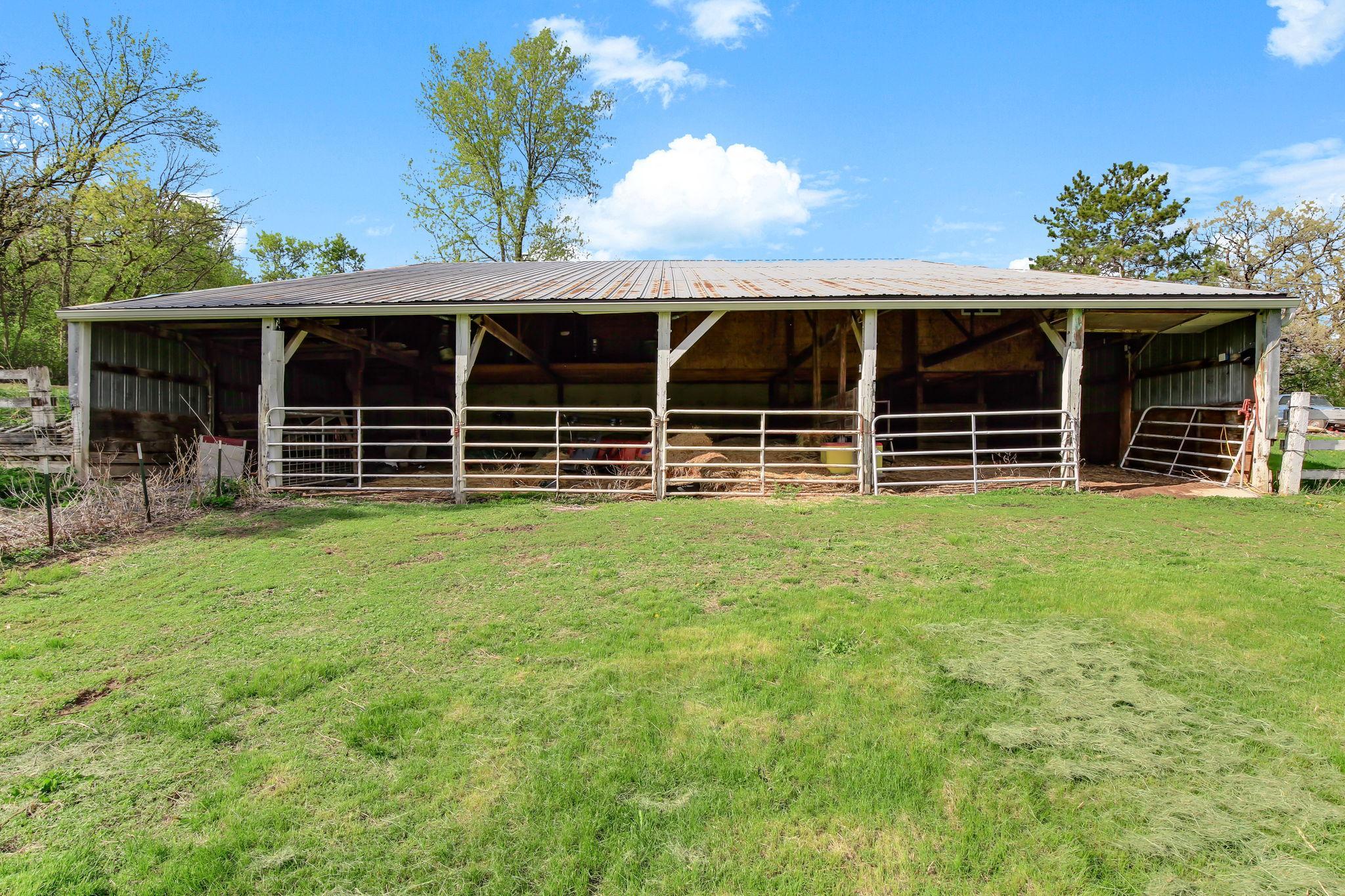 View of stalls going into fenced pasture.