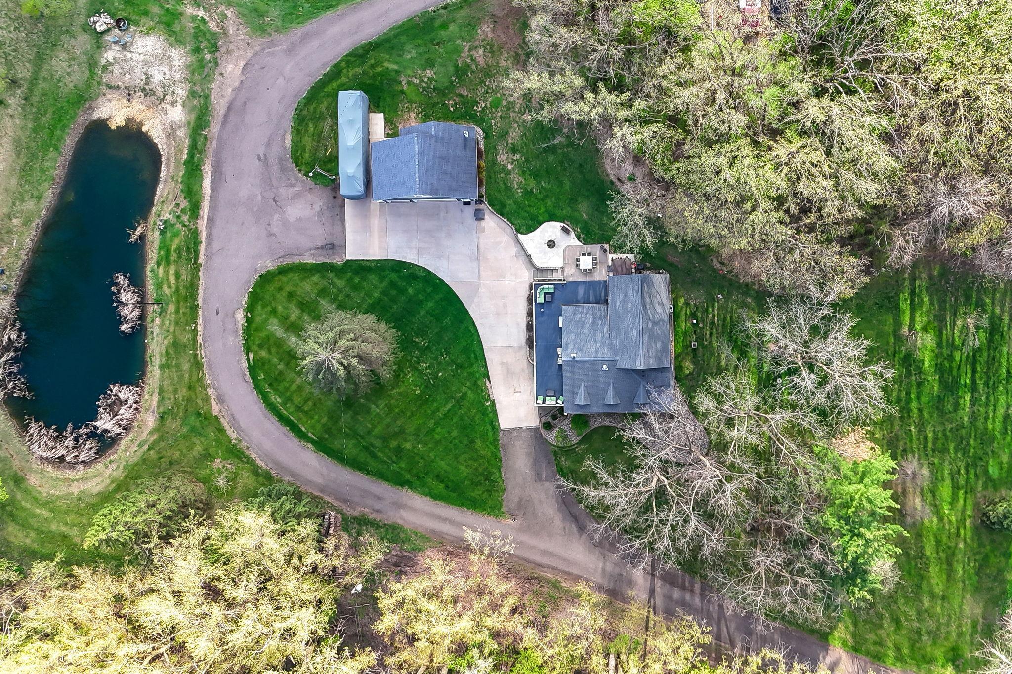 Aerial from overhead shows the pond, house and main detached garage.